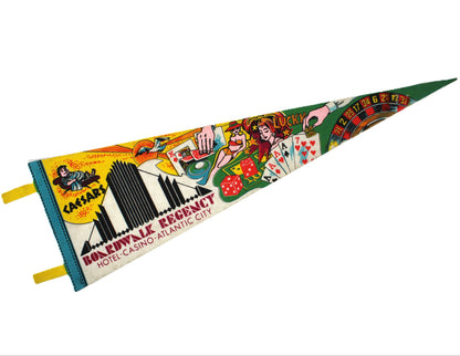 A vintage triangular felt pennant flag featuring colorful illustrations and text for 'Boardwalk Regency Hotel Casino Atlantic City,' including playing card suits, dice, and casino-themed graphics, shown on a plain white background.