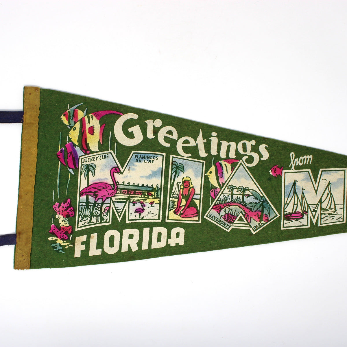 A vintage-style triangular felt pennant reading 'Greetings from Miami Florida' in large decorative letters, with illustrated tropical scenes and flamingos on a white background.