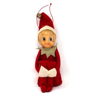 A vintage Christmas Elf doll ornament in a red and white suit with a small gold bell on its hat, shown against a plain white background.