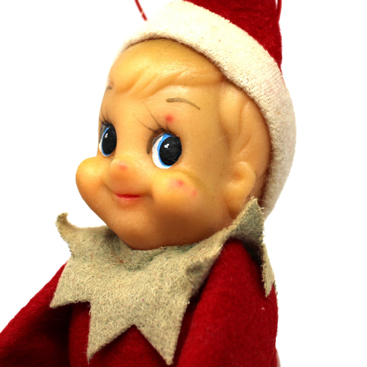 Vintage Christmas elf doll with blonde hair, blue eyes, wearing a red Santa hat and red outfit with a beige collar, photographed against a white background.