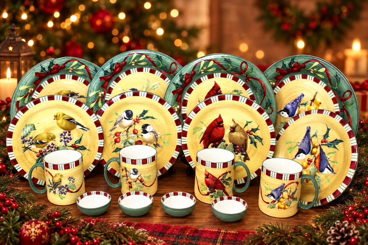 A holiday bird-themed dinnerware set including plates, mugs, and small bowls, decorated with colorful cardinals, goldfinches, bluebirds, and pinecones on a yellow background with green and red accents.
