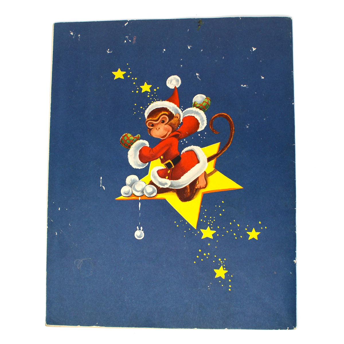 back cover of a vintage Christmas children's book, featuring a cartoon monkey dressed as Santa Claus riding a yellow star, set against a dark blue background with small yellow stars. 