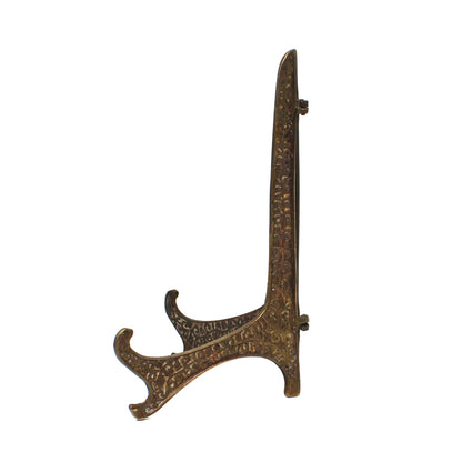 A vintage decorative tabletop stand with  an ornate, curved design, finished in a textured antique bronze.