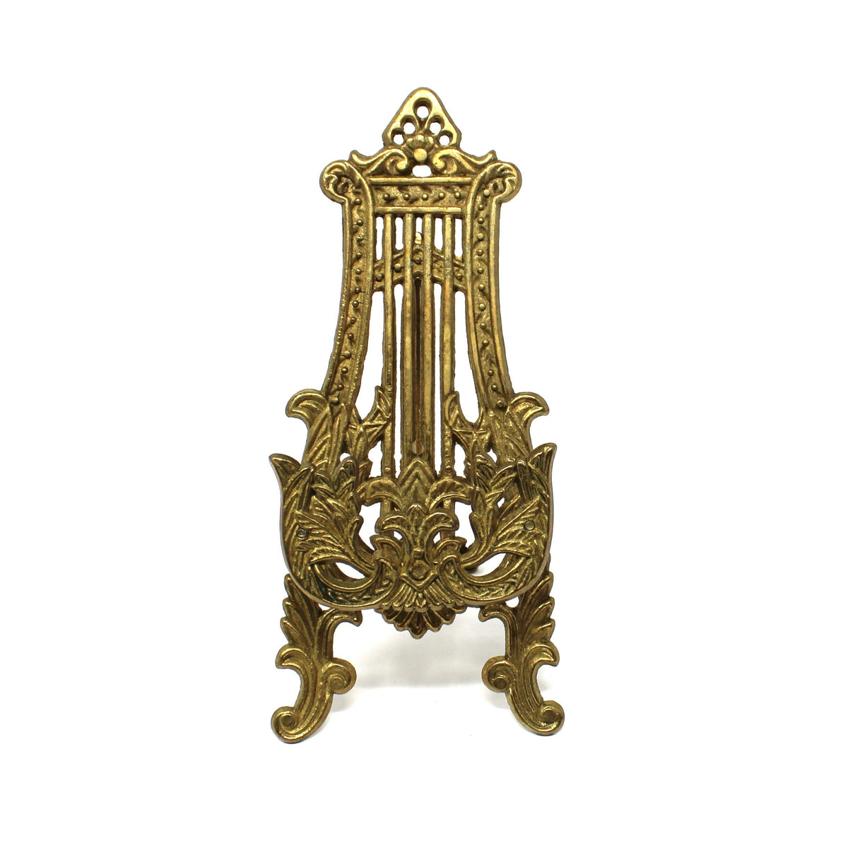 A vintage, ornate brass tabletop display stand / easel, resembling a gothic or baroque-style lyre or harp.