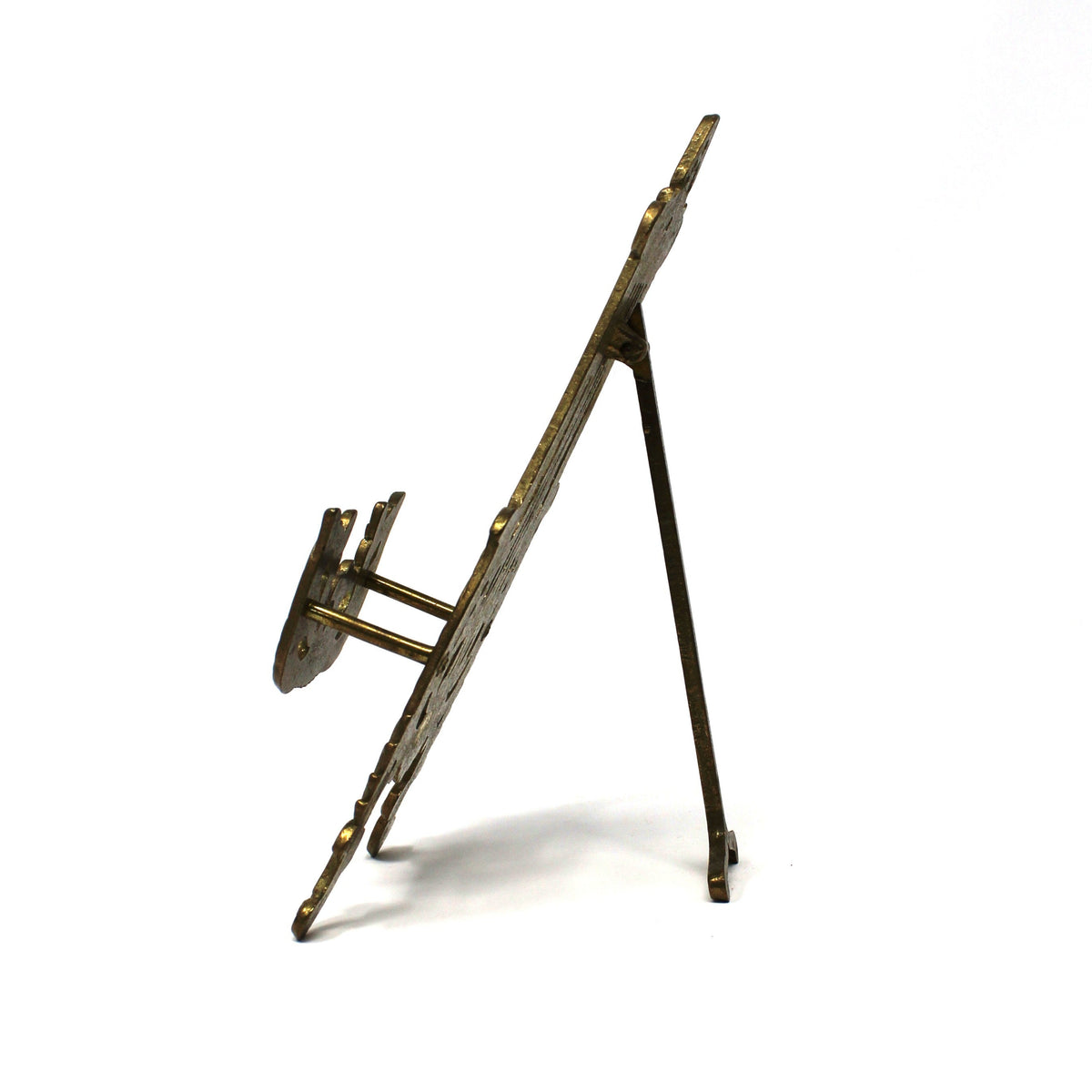 A vintage antique-style metal easel or display stand, opened with a slanted board and three legs.