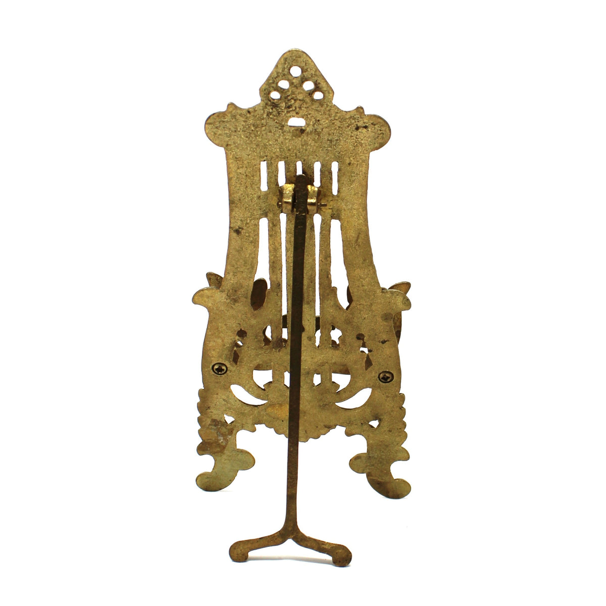 An ornate vintage brass stand with intricate cutout details and a three-legged base