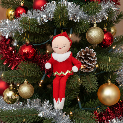 Vintage red pixie elf ornament on a Christmas tree with gold and red ornaments.