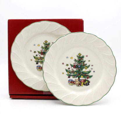 A vintage Nikko ceramic Happy Holidays Christmas salad plate with a decorated tree and presents, shown in front of a red gift box