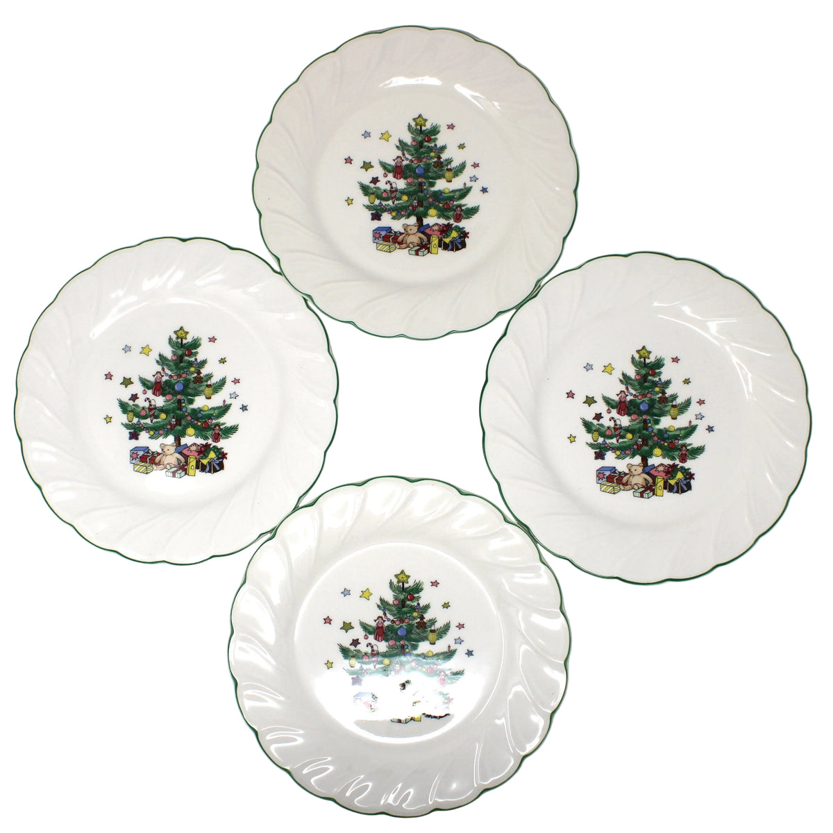 A set of Four vintage ironstone salad plates, NIKKO Happy Holidays Christmas pattern with scalloped edges, each decorated with a colorful Christmas tree and presents.