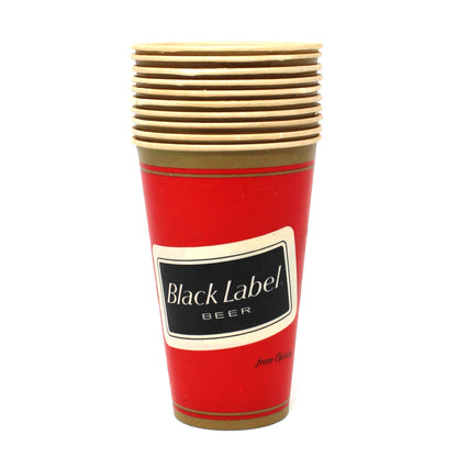 A stack of vintage Carling Black Label Beer disposable paper cups with a red body, gold rim and base. Unused