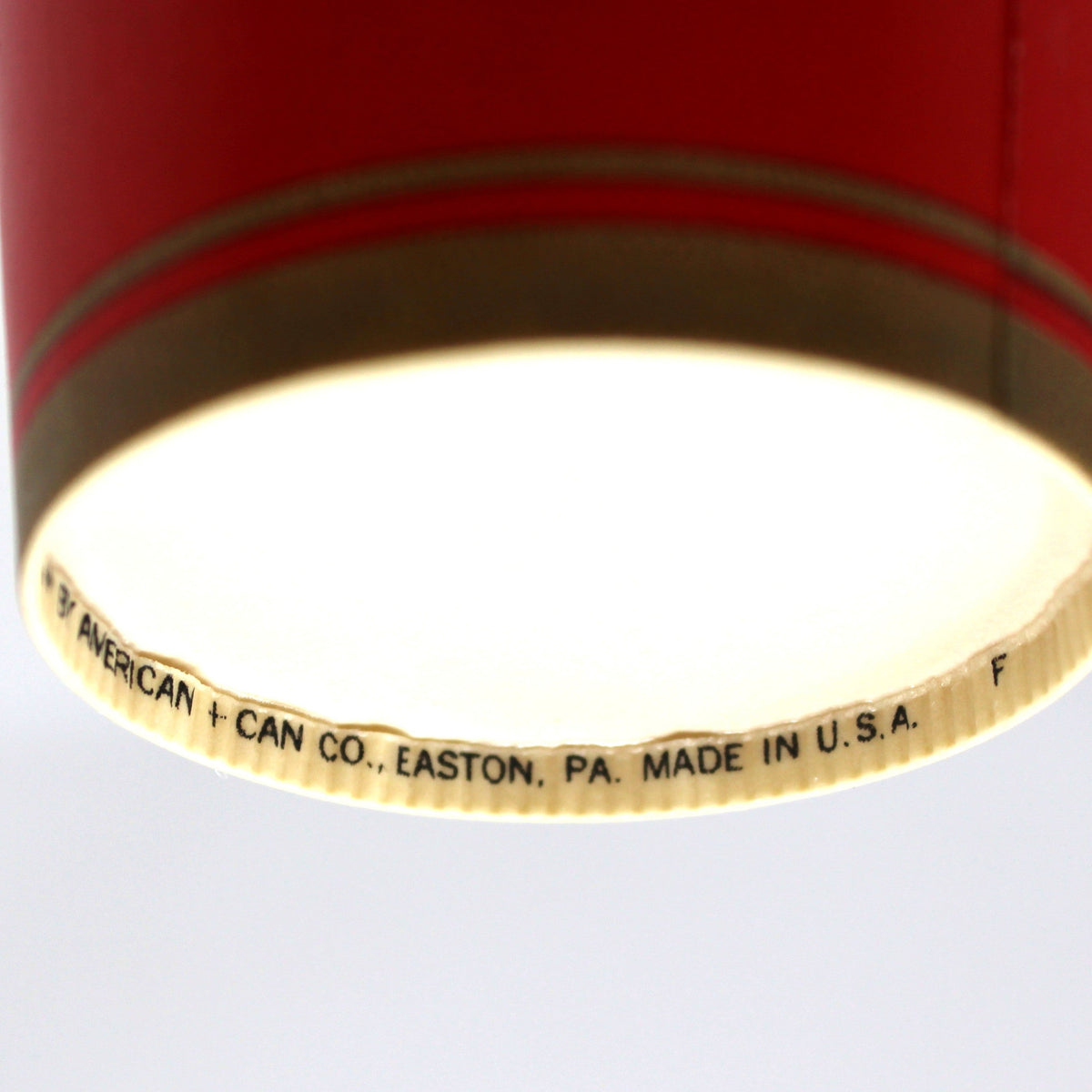 A close-up of the underside of a vintage paper cup, showing a white printed text that reads 'CAN CO. EASTON, PA., MADE IN U.S.A.