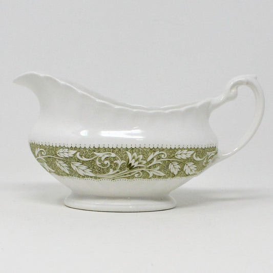 A vintage J&G Meakin Lucerne green and white ironstone gravy boat with floral patterns around the base.